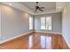 Primary bedroom with hardwood floors, ceiling fan and large windows at 9041 Chelsea Dr, Raleigh, NC 27603