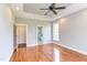 A bright bedroom with hardwood floors, gray walls, and an open door to the ensuite bathroom at 9041 Chelsea Dr, Raleigh, NC 27603