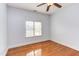 This light blue bedroom features a window, ceiling fan, and hardwood floors at 9041 Chelsea Dr, Raleigh, NC 27603