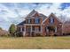 Stunning brick home featuring a manicured lawn, black shutters and a welcoming front porch at 9041 Chelsea Dr, Raleigh, NC 27603
