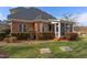Brick home exterior showcases a screened porch, well-maintained landscaping, and a classic architectural style at 9041 Chelsea Dr, Raleigh, NC 27603