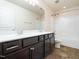 Bathroom boasts a double vanity with dark cabinets and tile flooring at 932 Peninsula Pl, Knightdale, NC 27545