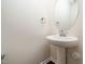Charming powder room features pedestal sink, oval mirror, and base trim at 932 Peninsula Pl, Knightdale, NC 27545