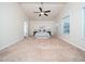 Spacious bedroom with neutral carpet, ceiling fan, large windows and base trim at 932 Peninsula Pl, Knightdale, NC 27545