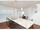 Stylish kitchen island with granite countertops, stainless steel sink, and dark wood cabinets at 932 Peninsula Pl, Knightdale, NC 27545