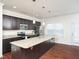 Modern kitchen with dark cabinets, granite countertops, and stainless steel appliances at 932 Peninsula Pl, Knightdale, NC 27545