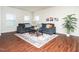 Bright living room with hardwood floors, comfortable seating, and a decorative rug at 932 Peninsula Pl, Knightdale, NC 27545