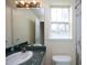 Well-lit bathroom with a window, a granite-look countertop, and a large mirror at 104 Hickory Glen Ln, Durham, NC 27703