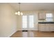 Cozy dining area features a chandelier, light wood floors, and French doors to the backyard at 104 Hickory Glen Ln, Durham, NC 27703