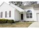 Close-up of a white-sided home featuring an arched window above the front door and a manicured lawn at 104 Hickory Glen Ln, Durham, NC 27703