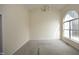 Bright living room features a large arched window, neutral walls, and patterned carpeting at 104 Hickory Glen Ln, Durham, NC 27703