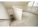 Carpeted staircase leading to bonus room with natural light and freshly painted walls at 104 Hickory Glen Ln, Durham, NC 27703