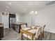 Bright dining area with wooden table, upholstered chairs, and modern chandelier, adjacent to kitchen at 105 Palladium Ct, Elon, NC 27244