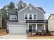 Charming two-story home featuring stone accents, a covered porch, and a well-manicured front yard at 105 Palladium Ct, Elon, NC 27244