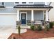 Inviting front porch with stone accents, elegant columns, a cozy bench, and a blue front door at 105 Palladium Ct, Elon, NC 27244