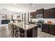 Spacious kitchen featuring a large island with seating, stainless steel appliances, and dark wood cabinets at 105 Palladium Ct, Elon, NC 27244