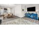 Well-lit living room open to dining area featuring grey floors, TV, and blue cabinet at 105 Palladium Ct, Elon, NC 27244