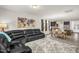 Spacious living room featuring an open floor plan to kitchen and dining area with gray toned flooring at 105 Palladium Ct, Elon, NC 27244