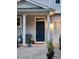 Inviting front door with decorative wreath, porch seating, and a well-lit entryway at 108 Palmdale Ct, Holly Springs, NC 27540