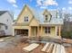 Attractive home under construction with yellow siding, a cozy porch, and an attached garage at 108 Pointe Park Cir, Holly Springs, NC 27540