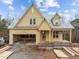 Charming home under construction featuring yellow siding, a welcoming porch, and a convenient attached garage at 108 Pointe Park Cir, Holly Springs, NC 27540