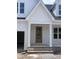 A close-up of the front entrance featuring a charming, light wood front door, brick base and white posts at 108 Pointe Park Cir, Holly Springs, NC 27540