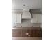 Close-up of white kitchen cabinetry with range hood at 108 Pointe Park Cir, Holly Springs, NC 27540