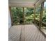 Screened porch with wood flooring offers a view of surrounding trees providing the perfect relaxing and tranquil outdoor space at 108 Pointe Park Cir, Holly Springs, NC 27540