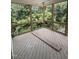 Large screened porch features wood flooring and a wood framed opening with iron railing, providing a view of the lush backyard at 108 Pointe Park Cir, Holly Springs, NC 27540