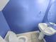 This is a half bathroom with vibrant blue walls, a white pedestal sink and a toilet at 117 Woodson Dr, Clayton, NC 27527