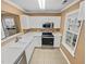 A modern kitchen with white cabinets, tile floors, and stainless steel appliances at 117 Woodson Dr, Clayton, NC 27527
