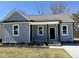 Charming single-story home with a covered porch, gray siding, and a well-manicured front yard at 119 Daniel St, Oxford, NC 27565