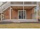 Features a brick exterior, covered porch with staircase, and sliding glass door for access to the backyard at 1203 Brookgreen Dr, Cary, NC 27511