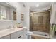 Cozy bathroom featuring modern vanity, framed mirror, and shower with brown-tiled enclosure at 1203 Brookgreen Dr, Cary, NC 27511
