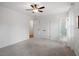 Bright bedroom featuring neutral carpet, white walls, a ceiling fan, and access to a bathroom and closet at 1203 Brookgreen Dr, Cary, NC 27511