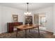 Elegant dining area featuring wooden table set, stylish light fixture and sliding doors to the patio at 1203 Brookgreen Dr, Cary, NC 27511