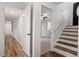 Bright hallway leading to bedrooms and stairs with wood-look flooring, white walls and natural lighting at 1203 Brookgreen Dr, Cary, NC 27511