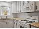 Well-lit kitchen with white cabinets, granite countertops, subway tile backsplash, and stainless steel appliances at 1203 Brookgreen Dr, Cary, NC 27511