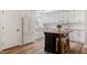 Bright kitchen featuring a dark wood island, white cabinets, granite countertops, and wood flooring at 1203 Brookgreen Dr, Cary, NC 27511