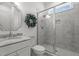 All-white bathroom featuring a glass shower with white and grey marbled tile, toilet, and sink with large vanity mirror at 1225 Perry Bluff Dr, Wake Forest, NC 27587
