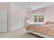 Pretty pink bedroom with a decorative chandelier and window at 1225 Perry Bluff Dr, Wake Forest, NC 27587