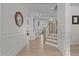 Bright foyer featuring wood floors, white wainscoting, a staircase, and an arched doorway at 1225 Perry Bluff Dr, Wake Forest, NC 27587