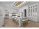 Spacious white kitchen with island, stool seating, pendant lighting, and custom cabinets is perfect for entertaining at 1225 Perry Bluff Dr, Wake Forest, NC 27587