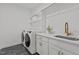 Convenient laundry room with modern washer and dryer, sink, and storage at 1225 Perry Bluff Dr, Wake Forest, NC 27587