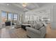 Sun-filled living room with grey couches, ottoman, patterned rug, and sliding glass doors leading to the outdoors at 1225 Perry Bluff Dr, Wake Forest, NC 27587