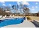 Inviting backyard pool with a stone waterfall feature, lounge chairs, and a view of the surrounding landscape at 1225 Perry Bluff Dr, Wake Forest, NC 27587