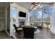 Relaxing sunroom features a stone fireplace, comfortable seating, ceiling fan, and serene outdoor views at 1225 Perry Bluff Dr, Wake Forest, NC 27587