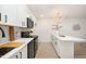 Modern kitchen with white cabinets and black appliances, illuminated by a stylish chandelier at 130 S Estes Dr # F6, Chapel Hill, NC 27514