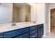 Bathroom featuring double sinks with blue cabinets, a large mirror, and modern fixtures at 133 Oban Dr, Homesite 151, Sanford, NC 27330