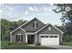 Charming home with gray siding, white trim, a black front door, and an attached garage at 133 Oban Dr, Homesite 151, Sanford, NC 27330